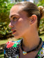 Close up model image of Venessa Arizaga FW26 Venus Heart Necklace (Black) - A statement necklace with black glass beads, pave accents, and a gold heart pendant, perfect for everyday wear