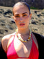 Model image of Venessa Arizaga FW26 Glitter Galaxy Necklace - A golden beaded necklace with classic icons - rainbow, smiley, alien, daisy, yin-yang, clover, star - perfect for everyday layering. Colorful beaded necklace with smiley face, evil eye, ladybug, four-leaf clover, and daisy.