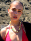 Model image of Venessa Arizaga FW26 Glitter Galaxy Necklace - A golden beaded necklace with classic icons - rainbow, smiley, alien, daisy, yin-yang, clover, star - perfect for everyday layering. Colorful beaded necklace with smiley face, evil eye, ladybug, four-leaf clover, and daisy.