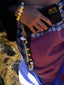 Model image of Venessa Arizaga FW26 Glitter Galaxy Bracelet - A golden beaded bracelet with classic icons - rainbow, smiley, butterfly, eyeball, mushroom, clover - perfect for everyday layering, and Glitter Galaxy Phone Leash - A golden beaded phone strap/bag charm with ceramic and wooden charms in star, clover, bear, ladybug, butterfly, and flowers, perfect for making an everyday statement.