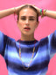 Surf-inspired adjustable multi-layer chain, thread and glass charms Color Crush Necklace worn long, Stacked with Adjustable Love in Color Necklace worn as a choker, with Adjustable Color Crush multi layer bracelet, a stack of Brightside Charm and Cord everyday bracelets, and sparkling rhinestone stud and pave peace sign charm dangling earrings, styled with SS26 resort wardrobe, close-up on a model for a sunny resort look by Venessa Arizaga.