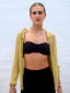 Venessa Arizaga SS26 Good Vibes Only adjustable layered smiley and pearl Bracelet and Happy Mood elastic bracelet with white jade and key charm on wrists, Good Vibes Only Necklace draped at the collarbone, smiley charms dancing against bronzed skin for happy-go-lucky salt-air resort energy, with sparkling stud and charm dangling earrings - Peace Out Sparkle Earrings and Smiley Sparkle Earrings, perfect for radiating happiness and positivity.