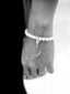 Close-up of the gold-plated brass key charm on the Happy Mood elastic jade bead bracelet