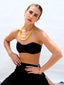 Venessa Arizaga SS26 Good Vibes Only Bracelet on wrist — adjustable black threadwork with multi-layer gold chains, glass pearls, and beaming smiley face charms; adjustable friendship bracelet design radiating handmade positivity, with rainbow and neon glass pearls Happy AF Elastic Bracelet, and Sugar Rush Necklace (Smile) made with leather cord, glass and ceramic charms with happy face draped over the collarbone.