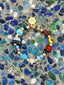Venessa Arizaga FW26 Cosmic Roadtrip Bracelet - A golden beaded bracelet with classic icons - camera, smiley, butterfly, star, cactus, ladybug - perfect for everyday layering. Colorful beaded bracelet with various charms on a textured surface.