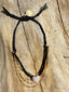 Lifestyle image of Venessa Arizaga FW26 Sweetheart Sparkle Bracelet (Black) - A layered bracelet with black threadwork, seed beads, gold plated chains, rhinestone chain, and a pave heart charm. Multistrand bracelet with gold and black beads on a wooden surface