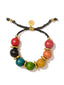 Venessa Arizaga Confetti Bracelet - An adustable bracelet with black threadwork, rainbow wooden charms and gold accents.