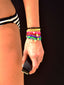 BRIGHT SIDE BRACELET (LUCKY HORSESHOE) - a stack of Brightside Charm and Cord everyday bracelets, and sparkling rhinestone stud and pave peace sign charm dangling earrings, styled with SS26 resort wardrobe, close-up on a model for a sunny resort look by Venessa Arizaga.