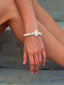 Model image of Venessa Arizaga SS26 UP IN THE CLOUDS BRACELET - an elastic freshwater pearl bracelet with cloud charm, perfect for every day layering