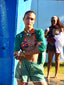 Model image of Venessa Arizaga FW26 Over The Rainbow Necklace & Bracelet - A colorful beaded statement necklace and bracelet with rainbow gradient charms including heart, flower, smiley, clover, eyeball, mushroom, butterfly, bead, and ladybug in ceramic, wood, and glass, and Over The Rainbow Phone Leash, a statement multi use phone accessory and bag charm with iconic charms in rainbow hues.