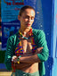 Model image of Venessa Arizaga FW26 Over The Rainbow Necklace & Bracelet - A colorful beaded statement necklace and bracelet with rainbow gradient charms including heart, flower, smiley, clover, eyeball, mushroom, butterfly, bead, and ladybug in ceramic, wood, and glass, and Over The Rainbow Phone Leash, a statement multi use phone accessory and bag charm with iconic charms in rainbow hues.