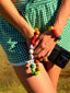 Close up model image of Venessa Arizaga FW26 Over The Rainbow Bracelet - A colorful beaded statement bracelet with rainbow gradient charms including heart, flower, smiley, eyeball, and ladybug in ceramic, wood, and glass, and FW26 Over The Rainbow Phone Leash- A colorful beaded statement multi use phone accessory and bag charm with iconic charms in rainbow hues including heart, flower, smiley, clover, eyeball, mushroom, butterfly, bead, and ladybug in ceramic, wood, and glass.
