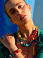 Close up model image of Venessa Arizaga FW26 Over The Rainbow Necklace & Bracelet - A colorful beaded statement necklace and bracelet with rainbow gradient charms including heart, flower, smiley, clover, eyeball, mushroom, butterfly, bead, and ladybug in ceramic, wood, and glass.