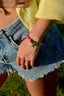 Model image of Venessa Arizaga FW26  Stardust Kiss Bracelet - A colorful adjustable bracelet with brown threadwork, colorful beads, pave accents, and a gold star pendant, perfect for every day layering