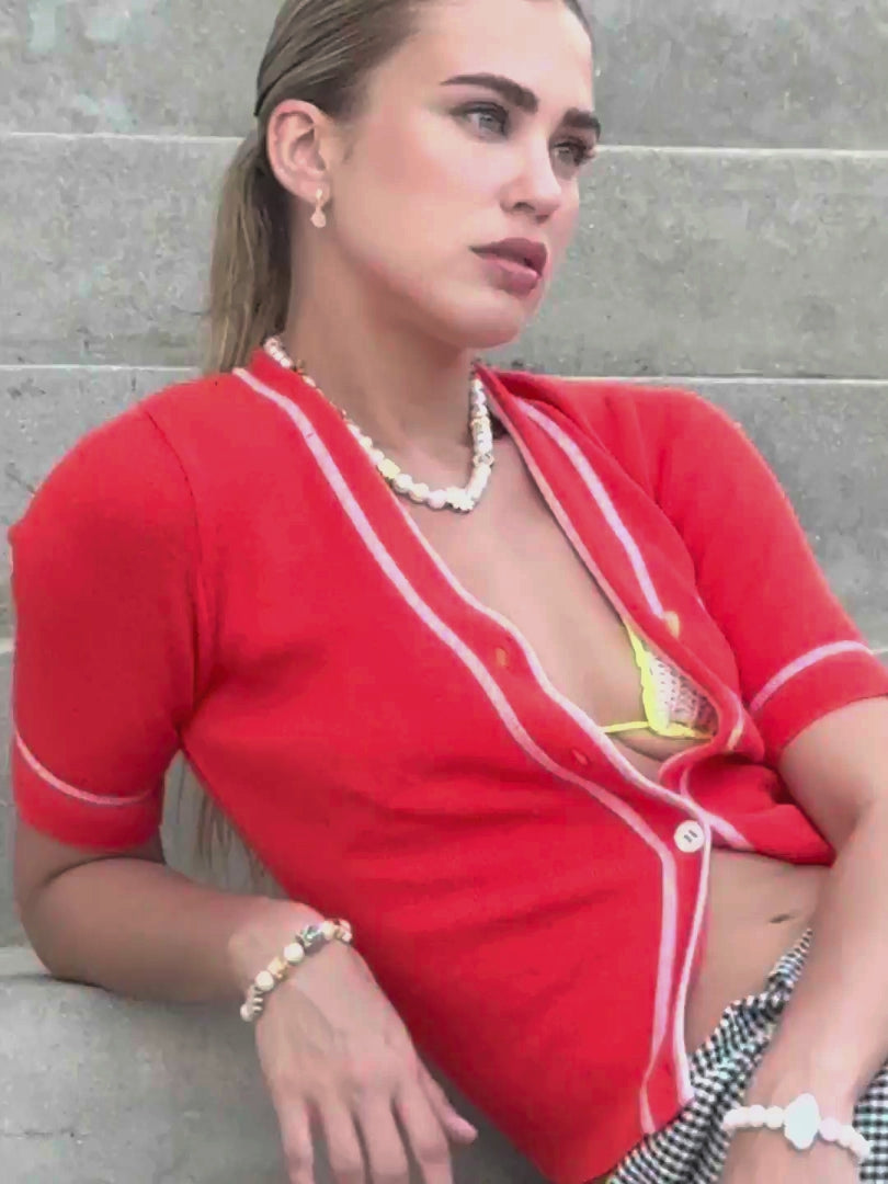 Venessa Arizaga SS26 Dreamy Days Pearl Bracelet wrapped on sun-kissed wrist, Dreamy Days Pearl Necklace layered delicately on the collarbone, and shining Peace Out Sparkle rhinestone stud and pave charm earrings, styled for a carefree vacation look.