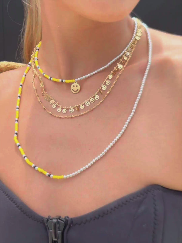 Close up Video of Venessa Arizaga SS26 Good Vibes Only Necklace draped at the collarbone, smiley charms dancing against bronzed skin for happy-go-lucky carefree resort energy and whimsical layering