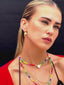 Close up video of Venessa Arizaga SS26 Rainbow Aura Necklace layered at collarbone with the Rainbow Heartbeat Adjustable Necklace worn as a choker, styled with Peace Out Sparkle Earrings and Shimmer Huggie Hoops Pave earring with mushroom, perfect for a sun-drenched Paradisiac escape and effortless beach vibe.